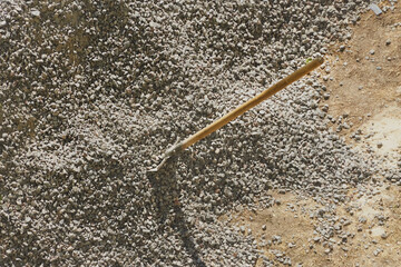 A shovel is embedded in a pile of gravel at a construction site, working with gravel at a...