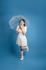 Portrait of beautiful Asian woman posing on blue background.