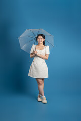 Portrait of beautiful Asian woman posing on blue background.