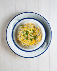 Scrambled eggs with baby eels and garlic. Top view table with  decorations.