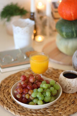 Pumpkins, various food and drinks, fall decorations, books and candles on the table. Fall hygge at home. Selective focus.