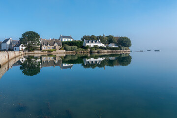 Fototapeta premium Peaceful coastal houses reflected in water on Île de Saint-Cado