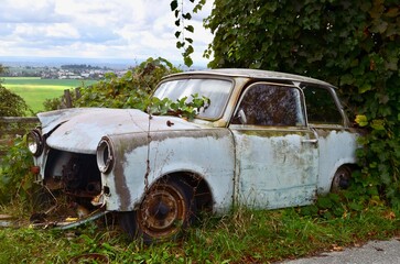 old rusty retro car overgrown with grass