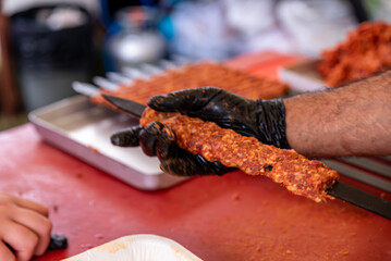 Man hand preparing traditional delicious Turkish shish kebab skewer made of lamb liver.