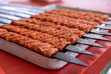 Man hand preparing traditional delicious Turkish shish kebab skewer made of lamb liver.