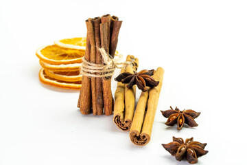 Cut orange and different spices  on white background. Traditional festive winter beverage.Cinnamon, dried orange, anise and cloves