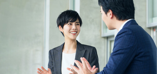 オフィスで会話するビジネスパーソン