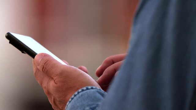 The fingers of a person using an unidentifiable mobile phone