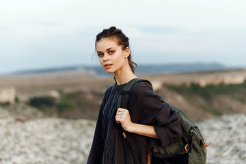 adventurous woman overlooking vast ocean from hilltop with backpack