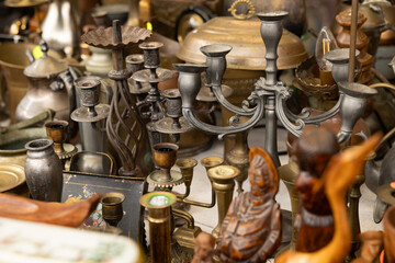Antiques, old things, religious symbols, figurines, old ceramics and accessories for the home, offered at a market stall. Haagse Market in The Hague, Netherlands.
