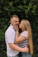 Fototapeta premium A man and a woman are kissing each other. The man is wearing a white shirt and the woman is wearing a striped shirt