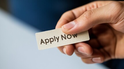 Close-Up of Hand Holding "Apply Now" Card: Urgency and Opportunity in a Modern Job Market