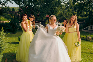 A bride is surrounded by her bridesmaids in a yellow dress