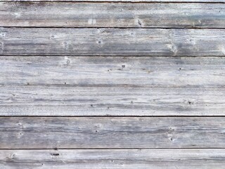Fototapeta premium Weathered wooden planks in a rustic setting during bright daylight