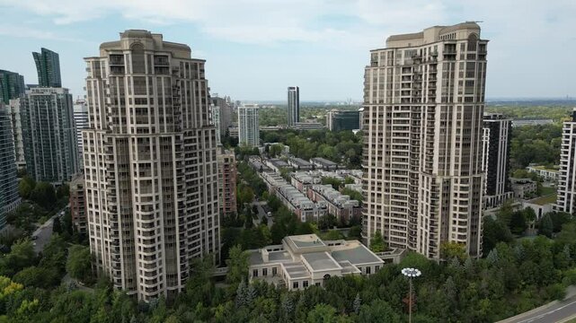 tunning aerial drone footage capturing high-rise residential towers near the 401 expressway and Yonge Street in Toronto. The dynamic shots highlight the contrast between the bustling highway, lush gre