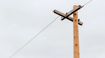Obraz premium This view showcases a broken telephone pole leaning to the side, with wires dangling against a dark, overcast sky, creating a moody atmosphere in the landscape