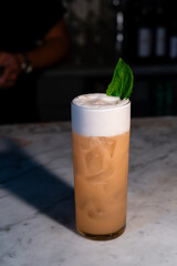 Close-up Orange & Mint Cocktail with Foam at High-End Bar