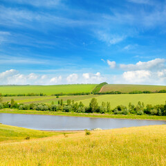 Fototapeta premium Agricultural fields, meadows, lake and sky.