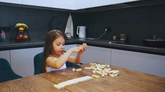 In kitchen, a cheerful child joyfully plays with a wood block tower, fostering creativity and imagination while exploring their surroundings with endless joy and curiosity
