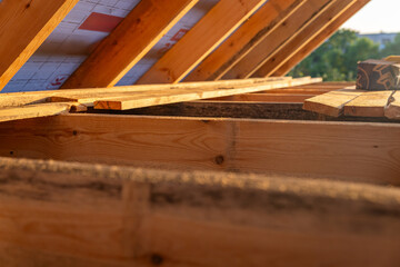 Under-construction residential wooden frame home located near a forest. Commencement of a new construction project for a cozy house or a mountain cottage. Idea of contemporary ecological construction.