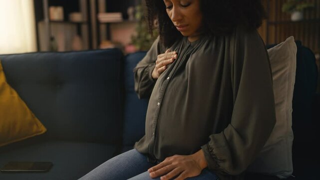 Pregnant woman suffering strong breast pain, holding her chest, risk of mastitis