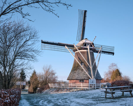 Windmill of Makkum in the snow on a bright januari morning after a light snow fall