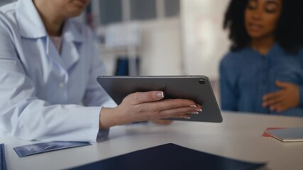 Obstetrician showing fetus ultrasound image to pleased pregnant female patient