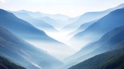 Obraz premium Misty mountain range with a valley in the distance, bathed in a soft blue light.