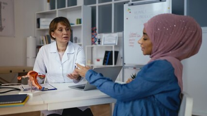 Obstetrician prescribing prenatal supplements to pregnant Muslim woman, health