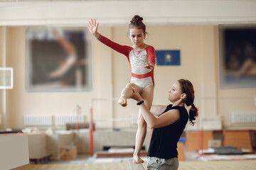 Prepare young child athlete gymnast on balance beam
