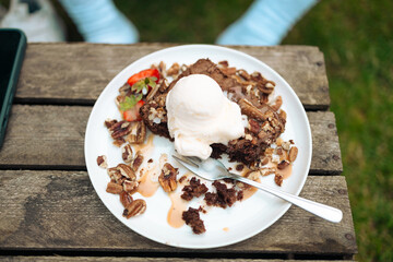 Homemade homemade brownie or chocolate cake with berries on brown wooden table at city cafe. High quality photo