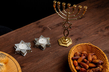 challah, honey, apple and pomegranate and burning candles on the table Shabbat Rosh Hashanah