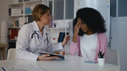 Doctor explaining analysis results to African American woman, bad diagnosis