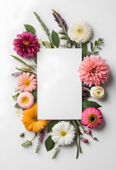 A blank white card surrounded by a vibrant arrangement of flowers. The flowers create a colorful border around the card, ideal for invitations or greeting cards.