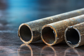 Rusty steel pipes with corrosion lie on a metal surface, components of metallurgy industry