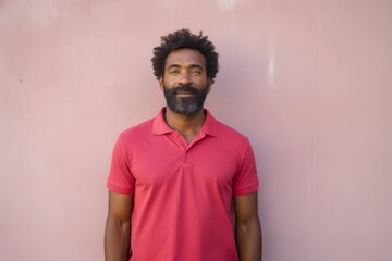 Obraz premium Portrait of a glad afro-american man in his 30s wearing a breathable golf polo in front of bare concrete or plaster wall