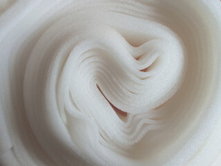 roll of thin white foam sponge. plain sheet of curved style texture material