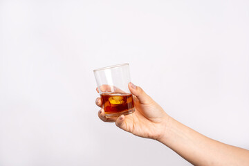 Photo of hand holding glass of alcohol isolated on white background. Alcohol concept