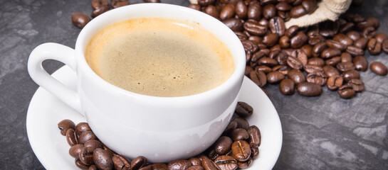 Coffee in white cup and roasted dark coffee beans in bag
