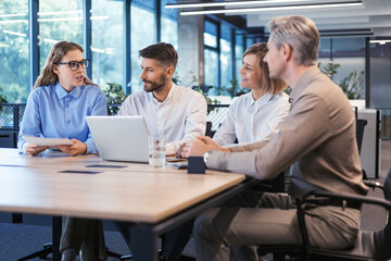 startup business team on meeting in modern bright office interior brainstorming, working on laptop and tablet computer.