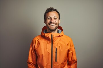 Fototapeta premium Portrait of a happy man in his 30s wearing a windproof softshell isolated in light wood minimalistic setup
