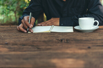 Close up hands of man sitting office desk holding sweet coffee cup relax and enjoy with happy time. Hot coffee mug in hand. Man holding coffee cup relaxing after work at office warm taste in cafe