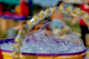 close-up of bubbles and foam, water games at a children's birthday party outdoors. soap bubble game and playful in childhood