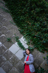 30-year-old medium-sized woman in a red muslin dress in an autumn garden
