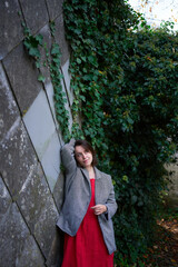 30-year-old medium-sized woman in a red muslin dress in an autumn garden
