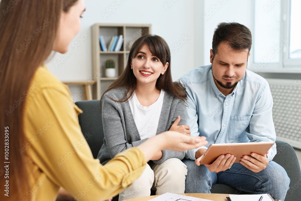 Poster designer discussing project with clients at table in office