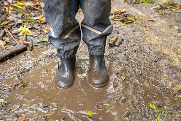 Child in welly boots, jump, jumping in mud.