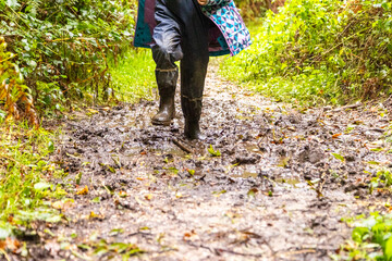 Child in welly boots, jump, jumping in mud.
