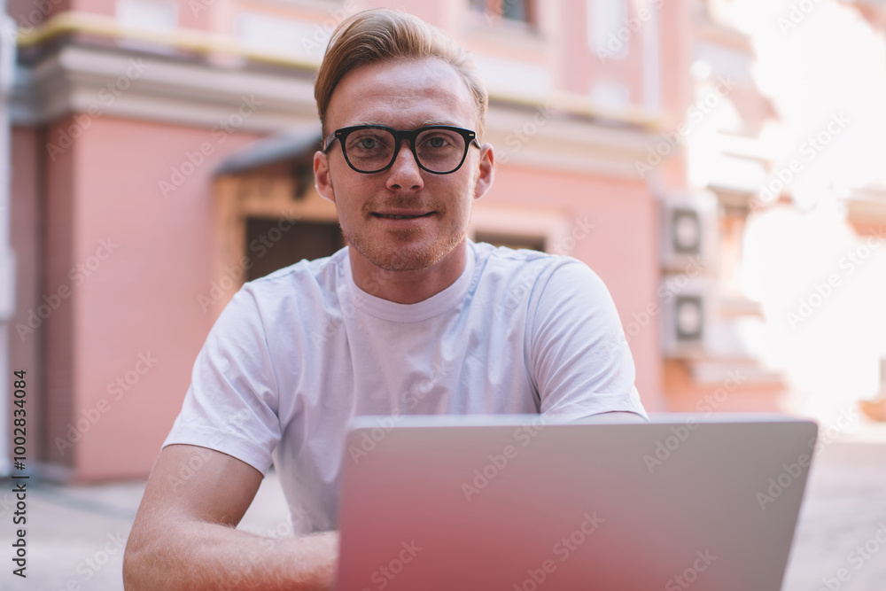 Aufkleber portrait of skilled male it professional in stylish eyewear looking at camera during break from onli