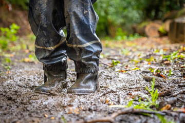 Child in welly boots, jump, jumping in mud.
